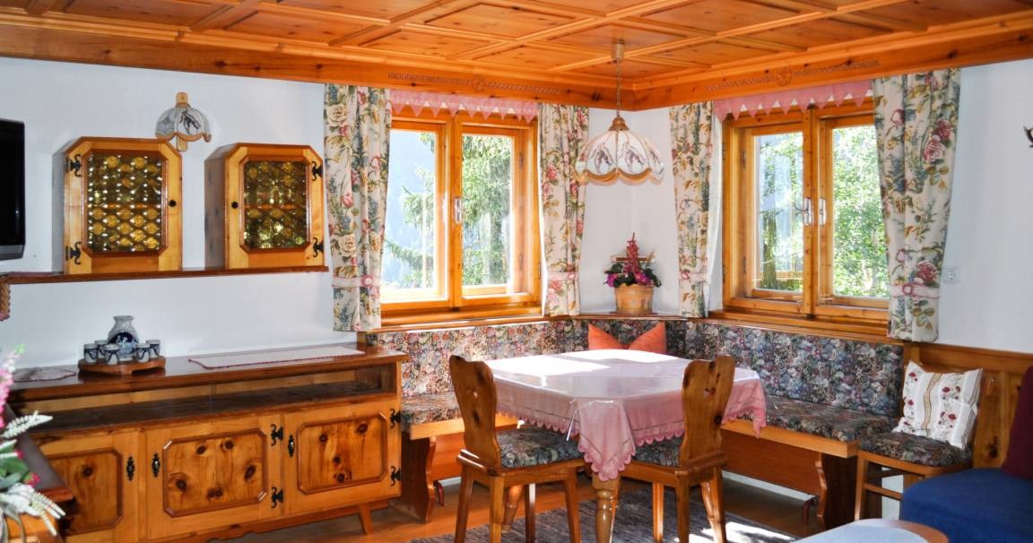 Living room with wooden ceiling and dining area at Holiday Home Schönblick